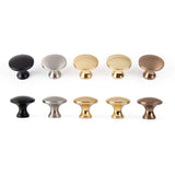 Tien ronde kastknoppen in twee rijen, elk in een andere metallic afwerking: zwart, zilver, goud en brons. Op de bolle onderste rij staat de Antoni Matte Gold knop van yessential.nl met zijn stijlvolle matgouden ontwerp.