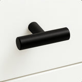 De Remo Black knop van yessential.nl heeft een minimalistisch T-vormig ontwerp in matzwart en voegt moderne elegantie toe aan een glad wit ladefront.