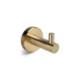 De Lorenzo Gouden Wc-set van yessential.nl heeft een enkele gouden wandhaak met een ronde basis en een cilindrische knijper, perfect om je badkameraccessoires op te leuken. Gepresenteerd tegen een effen witte achtergrond.