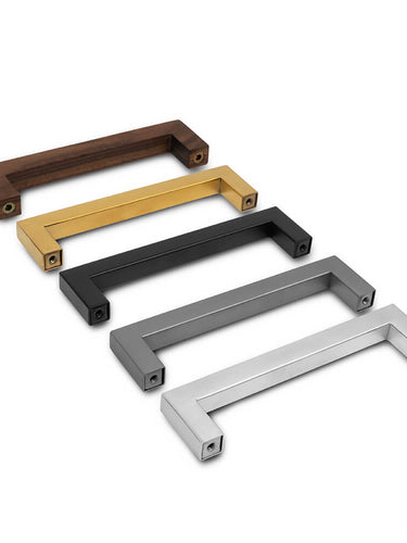Vijf Vasco Gold meubelknoppen van yessential.nl staan diagonaal opgesteld, elk in een unieke afwerking - hout, goud, zwart, grijs en zilver - met een strak, modern minimalistisch ontwerp.
