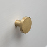 De Marizo Gold ronde knop van geborsteld messing van yessential.nl wordt gemonteerd op een lichtgrijs of wit vlak oppervlak en brengt elegante verfijning in elke ruimte.
