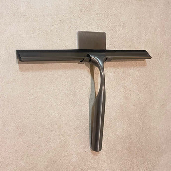 Een Zamoro Gunmetal van yessential.nl rust op de tegelvloer, het roestvrijstalen handvat glanst in het licht.