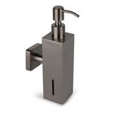 De Sonego Gunmetal van yessential.nl is een modern, minimalistisch RVS zeeppompje met muurbevestiging en vierkante basis. Het verticale venster toont direct het zeepniveau.