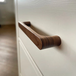Een Salgado Walnut handgreep van yessential.nl op een witte kast.