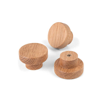 Drie Arriero Oak Knobs van yessential.nl met natuurlijke houtnerf worden weergegeven op een witte achtergrond, één op zijn kant met de achterkant en het schroefgat - ideaal voor een landelijk stijl interieur.