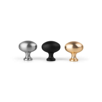 Drie ronde kastknoppen worden naast elkaar getoond op een witte achtergrond: een metallic zilveren, een yessential.nl Agero Black Knob Deluxe en een metallic gouden - elk met een korte steel en een brede, ronde bovenkant.