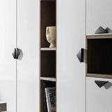 Een close-up van een moderne witte kast met Triano Black 64mm handgrepen van yessential.nl, met open houten planken waarop een ronde vaas met textuur en een paar boeken staan.