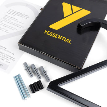 Een zwarte yessential.nl doos met een grote gele Y, het Amato Black 15cm huisnummer in zwart metaal, drie grijze pluggen, drie schroeven, drie zwarte afstandhouders en een instructieblad op een wit oppervlak.