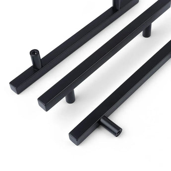 Drie Marano Black handgrepen van yessential.nl, met een strakke matzwarte afwerking en cilindrische steunen, zijn diagonaal geplaatst op een witte achtergrond.