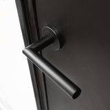 Een close-up van de Lucio Black deurklink van yessential.nl, met een matzwarte cilindrische greep horizontaal gemonteerd op een donkere deur - een strak voorbeeld van moderne zwarte deurklinken.
