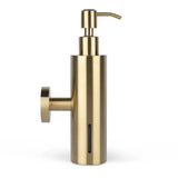 De Alberto Gold van yessential.nl is een cilindrische zeepdispenser in geborsteld goud, met een muurbevestiging aan de linkerkant, een pomptop en een verticaal venster om het zeepniveau aan te geven.
