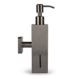 De Sonego Gunmetal van yessential.nl is een moderne zeepdispenser voor wandmontage met een rechthoekige behuizing, een pomptop, een verticaal zeepniveauvenster en een geborstelde metalen afwerking voor een strakke look.