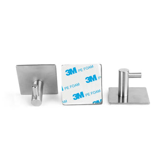 Drie Tapio RVS WC Set haken van yessential.nl zijn afgebeeld: één rechtop, één plat om de 3M achterkant te laten zien, en één schuin. Deze no-drill RVS wandhaken zijn perfect voor een stijlvolle badkamer of als RVS toiletaccessoires.