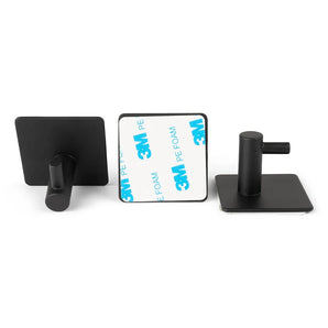 Vier zwarte zelfklevende haakjes uit de 4x Navarro Black set van yessential.nl worden getoond: één met het gezicht naar voren, één met de 3M achterkant en één vanaf de zijkant. Deze handdoekhaakjes hebben een modern RVS ontwerp met een vierkante basis.