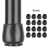 Close-up van een zwarte Paco Set Ø 25-29mm stoelpootdop van yessential.nl bevestigd aan een poot, met 16 soortgelijke doppen in een 4x4 grid rechts. Met anti-kras vilt voor vloerbescherming. '16 stuks' staat boven de doppen.