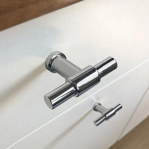 Close-up van de 10x Cordero Chroom knop van yessential.nl, gemonteerd op een witte kast - de ene knop is scherp, de andere onscherp. Een ideale keuze voor moderne interieurs die op zoek zijn naar stijlvolle chromen meubelknoppen.