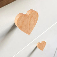 Een close-up van twee Bambino Heart ladegrepen van yessential.nl op een licht dressoir. Hun gladde, natuurlijke afwerking is perfect om charme toe te voegen aan een kinderkamer.