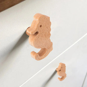 Close-up van twee Bambino Seahorse houten deurknoppen van yessential.nl op een lichte lade - ideaal voor de kinderkamer - met de ene knop scherp en de andere zachtjes onscherp op de achtergrond.
