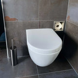 Een modern wit wandcloset met een gesloten deksel is gecombineerd met de Ludo Gunmetal WC Set (no-drill) van yessential.nl en een vierkante verzonken toiletpapierhouder, allemaal tegen donkergrijze betegelde muren en vloer.