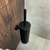 De Lauro Black WC-set van yessential.nl heeft een matzwart, strak cilindrisch ontwerp - deze wandclosethouder past perfect bij donker hout en beige tegels voor een verfijnde badkameraccessoireset.