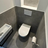 Een kleine, moderne badkamer met grijs betegelde muren, een wandcloset met dual-flush plaat en de Lorenzo Chroom WC set van yessential.nl, met een compacte wandwastafel en stijlvolle chromen accessoires voor een strakke afwerking.