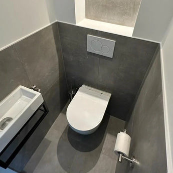 Een kleine, moderne badkamer met grijs betegelde muren, een wandcloset met dual-flush plaat en de Lorenzo Chroom WC set van yessential.nl, met een compacte wandwastafel en stijlvolle chromen accessoires voor een strakke afwerking.