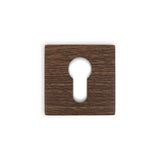 Een vierkant houten sleutelgatdeksel met een donkere walnoot nerf, voorzien van een klassiek centraal sleutelgat-perfect om te combineren met yessential.nl Rosettes Walnut-displayed tegen een witte achtergrond.