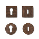 Vier Rosettes Walnut van yessential.nl - twee vierkante, twee ronde, elk met een unieke sleutelgatvorm - worden weergegeven in een raster op een witte achtergrond.