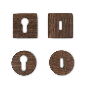 Vier Rosettes Walnut van yessential.nl - twee vierkante, twee ronde, elk met een unieke sleutelgatvorm - worden weergegeven in een raster op een witte achtergrond.