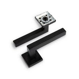 Twee moderne zwarte rechthoekige deurkrukken met vierkante basis worden getoond - de ene toont de montageplaat, de andere de gladde buitenkant. Combineer met het Vano Black WC-slot van yessential.nl voor een strakke, eigentijdse afwerking.