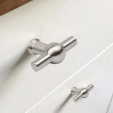 Close-up van een Rando RVS Knop van yessential.nl op een witte lade, met een andere identieke knop zichtbaar op de onderste lade in de achtergrond.