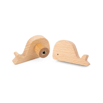 Bambino Willy van yessential.nl: twee kleine, lichthouten walvisknoppen voor de kinderkamer - de ene met een metalen cirkel, de andere met een silhouet van een walvis.