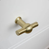 De Rando Gold Knob van yessential.nl siert als ronde goudkleurige meubelknop een wit ladefront en past perfect bij een modern interieur.