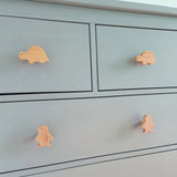 De Bambino Penquin commode van yessential.nl heeft vier lades met houten deurknoppen van schildpadden en pinguïns, wat zorgt voor speelse charme en een mooi contrast met de lichtgrijze afwerking - perfect als kinderkamer meubelknop.