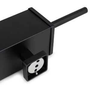 Eine Nahaufnahme der Alessino Black-Steckdosenleiste von yessential.de mit europäischer Steckdose und schwarzem Kabel, platziert neben einer mattschwarzen Toilettenbürste für einen eleganten, modernen Badezimmerstil.