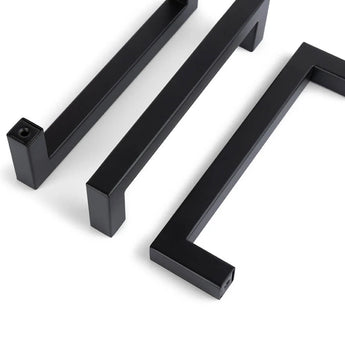 Drie Vasco Black kastgrepen van yessential.nl zijn diagonaal geplaatst op een witte achtergrond. Elke greep heeft een modern, minimalistisch design met strakke lijnen en scherpe hoeken.